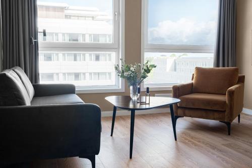 a living room with a couch and a table and two chairs at Bjørvika Apartments - Sirkus Renaa in Stavanger