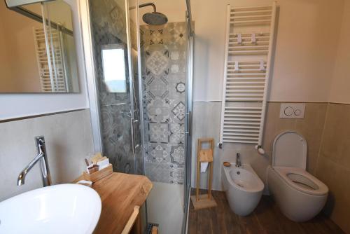 a bathroom with a shower and a toilet and a sink at Casale dei Briganti in Norcia