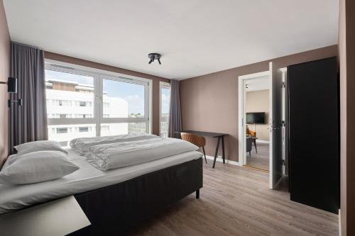 a bedroom with a bed and a large window at Bjørvika Apartments - Sirkus Renaa in Stavanger