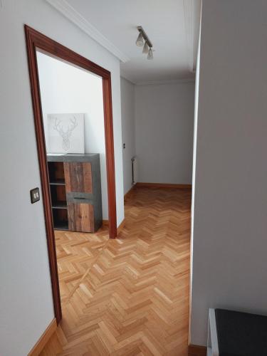 um quarto vazio com um espelho e um piso de madeira em FOZANELDI OVIEDO. Céntrico, accesible desde autovía y con PARKING em Oviedo