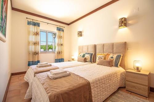 a bedroom with a large bed and a window at Casa Benagil Mar in Lagoa