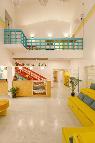 a living room with yellow furniture and a staircase at Locul Midtown-Indiranagar in Bengaluru