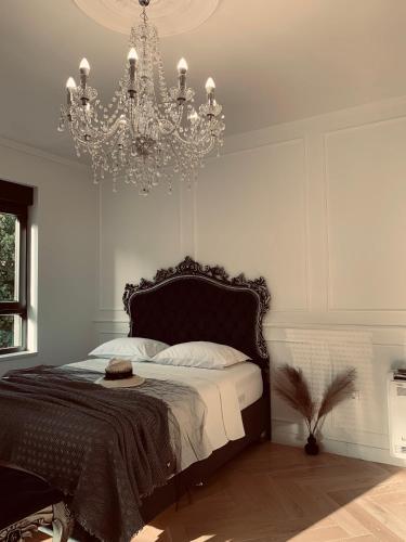 een slaapkamer met een groot bed en een kroonluchter bij Apartment Talija in Trebinje