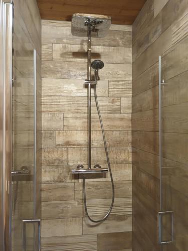 eine Dusche im Bad mit einer Holzwand in der Unterkunft Appartement montagne LE FLOCON in Saint-Michel-de-Chaillol