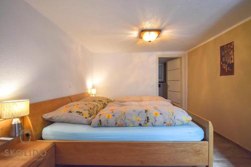 a bed in a room with two pillows on it at Casa Sunegga in Naters