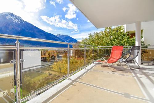 a balcony with two chairs and a view of mountains at Casa Sunegga in Naters