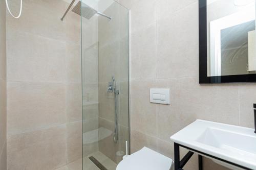 a bathroom with a shower and a toilet and a sink at Curoj Luxury Apartments in Radhimë