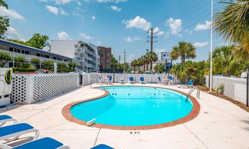 a swimming pool with lounge chairs around it at The Waterway Pet Friendly by Carolina Retreats in Wrightsville Beach