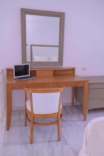 a wooden desk with a mirror and a laptop on it at Elizabeth Suites in Kato Daratso