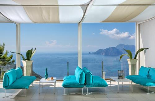 a room with blue chairs and a view of the ocean at Relais Blu in Massa Lubrense