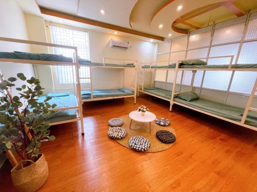 a room with three bunk beds and a table at GreenHome Hotel in Hai Phong