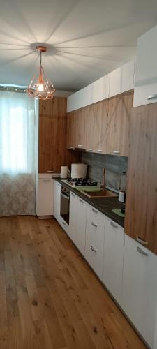 cocina grande con armarios blancos y suelo de madera en Shelter House, en Iaşi