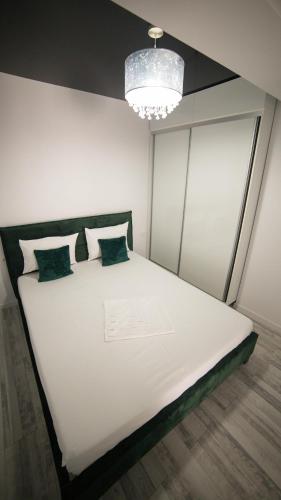 a large white bed in a room with a chandelier at Toto’s Apartment in Constanţa