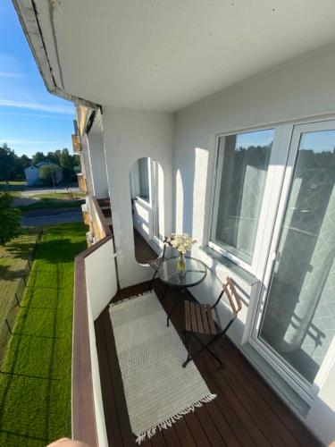 einen Balkon mit einem Glastisch und einem Fenster in der Unterkunft Cosy Studio in Haapsalu in Haapsalu