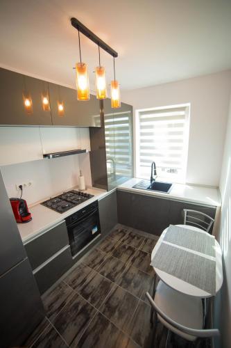 a kitchen with a table and a sink and a stove at Toto’s Apartment in Constanţa