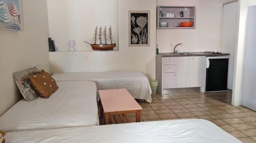 a living room with two beds and a kitchen at Pension Irene in Sougia