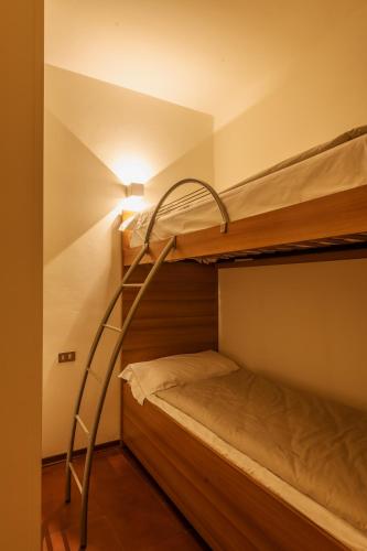 a room with two bunk beds with a ladder at Hotel Diffuso Locanda Elisa in Dimaro