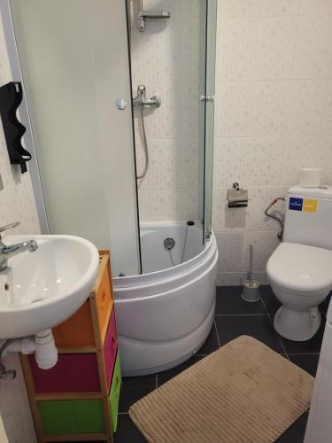 a bathroom with a tub and a sink and a toilet at Tac Premier in Ventspils