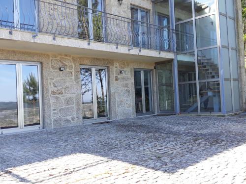 a building with a balcony and glass doors at Portela susa in Portela Susã
