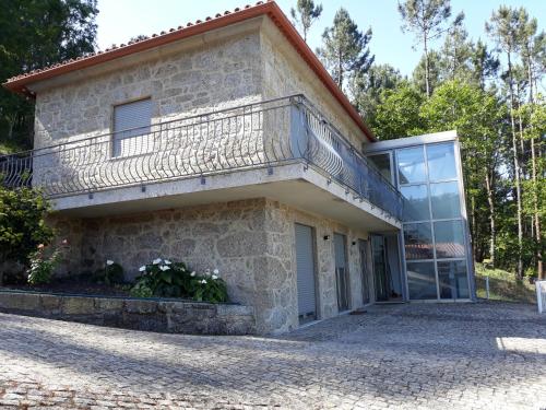 a house with a balcony on top of it at Portela susa in Portela Susã