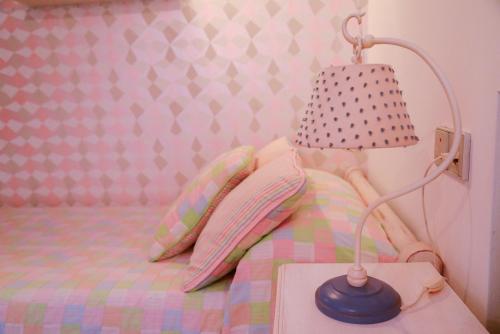 a bedroom with a bed with a lamp and pillows at Casa Paquita in Calpe