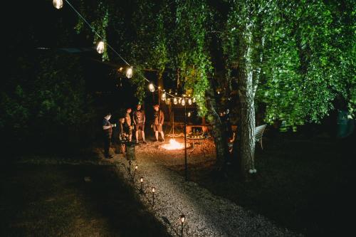 a group of people standing under a tree at night at Domek na wsi - Fyrtokfest in Frysztak