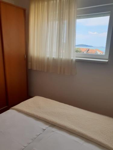 a bedroom with a bed and a window at Princess in Brodarica