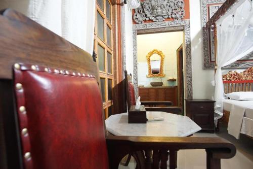 a room with a table and a bed and a mirror at Okawati Boutique Bungalows in Ubud