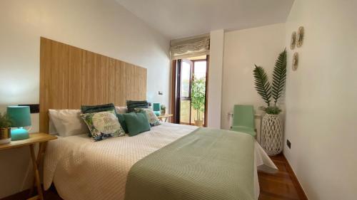 ein Schlafzimmer mit einem großen Bett mit grünen Kissen in der Unterkunft Ático Divina Home - Rias Baixas in Vilagarcia de Arousa