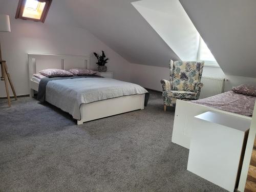 un dormitorio con una cama y una silla en Pokoje Gościnne Strażnica, en Jarosławiec