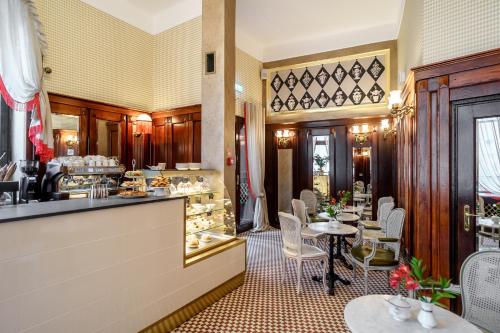 a restaurant with a counter and tables and chairs at Hotel H15 Francuski Old Town - Destigo Hotels in Kraków