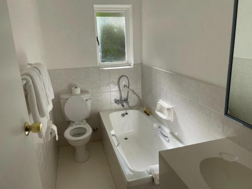 ein weißes Bad mit einem WC und einem Waschbecken in der Unterkunft Samoa Hotel in Moorreesburg