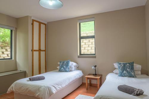 two beds in a room with two windows at Igna in Eersterivierstrand