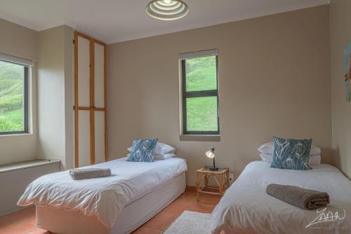 two beds in a room with two windows at Igna in Eersterivierstrand