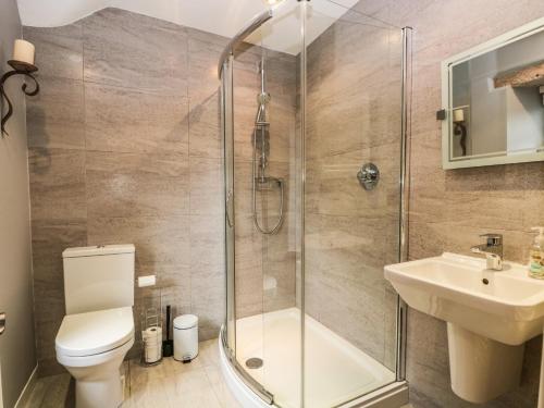 a bathroom with a shower and a toilet and a sink at The Lodge in Penrith