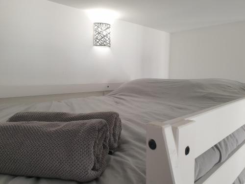 une chambre blanche avec un lit et une fenêtre dans l'établissement L'Olivier Proche Métro, à Marseille