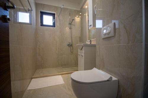 a bathroom with a toilet and a shower at Hotel Svarog in Becici