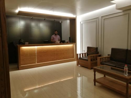 a man standing at a reception desk in a room at Hotel Hoque Tower International in Chittagong