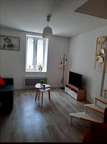 un salon avec un canapé et une table dans l'établissement Charmant logis en duplex, à Gérardmer