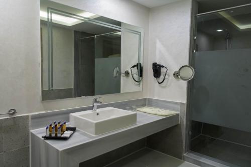 a bathroom with a sink and a shower at Pickalbatros Jungle Aqua Park - Neverland Hurghada in Hurghada