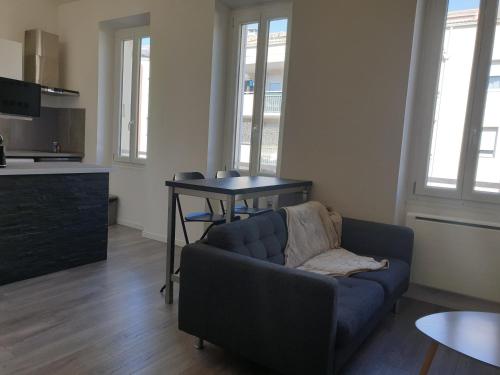 un salon avec un canapé bleu et une table dans l'établissement L'Olivier Proche Métro, à Marseille