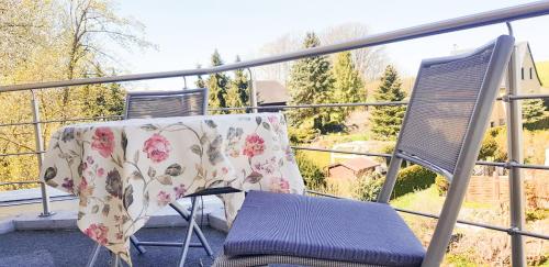 einen Tisch und einen Stuhl mit einem Tuch auf dem Balkon in der Unterkunft Schöne, helle, ruhige Wohnung und Wellness Sauna 