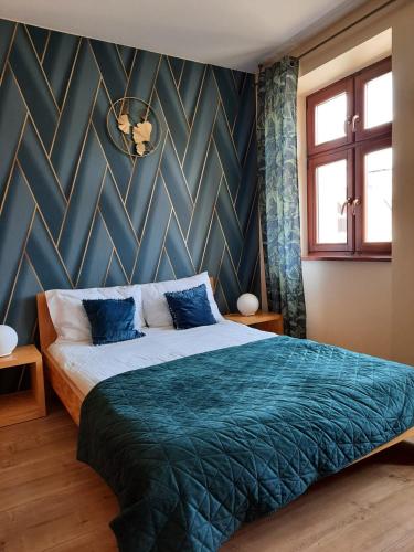 a bedroom with a large bed with blue sheets at APARTAMENTY T.R.11 Apartament nr 3 in Olsztyn