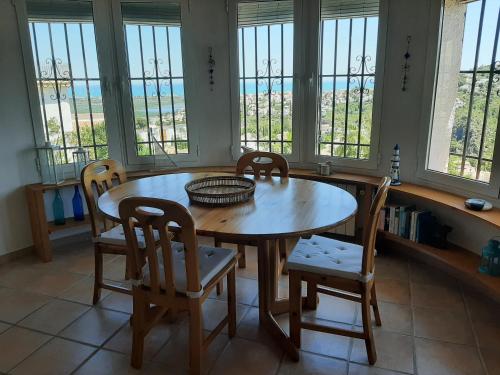 comedor con mesa, sillas y ventanas en Villa Felix, en Monte Pego