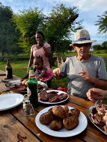 KashobaにあるLituba Lodgeの食卓に座る男