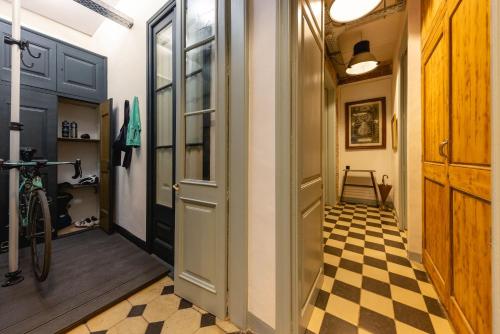 a hallway with a door and a checkered floor at Bravissimo Les Rajoles, Unique 3-bedroom apartment in Girona