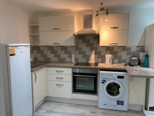 a kitchen with a washing machine and a washer at London retreat in Golders Green