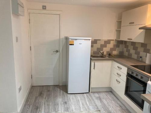 uma cozinha com um frigorífico branco num quarto em London retreat em Golders Green