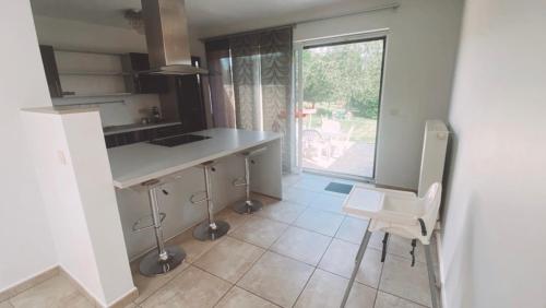 a kitchen with a counter and a table and chairs at Maison à 3,2km de l’aéroport in Charleroi