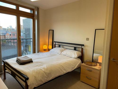 a bedroom with a large bed with a balcony at The Postbox by LFD in Birmingham